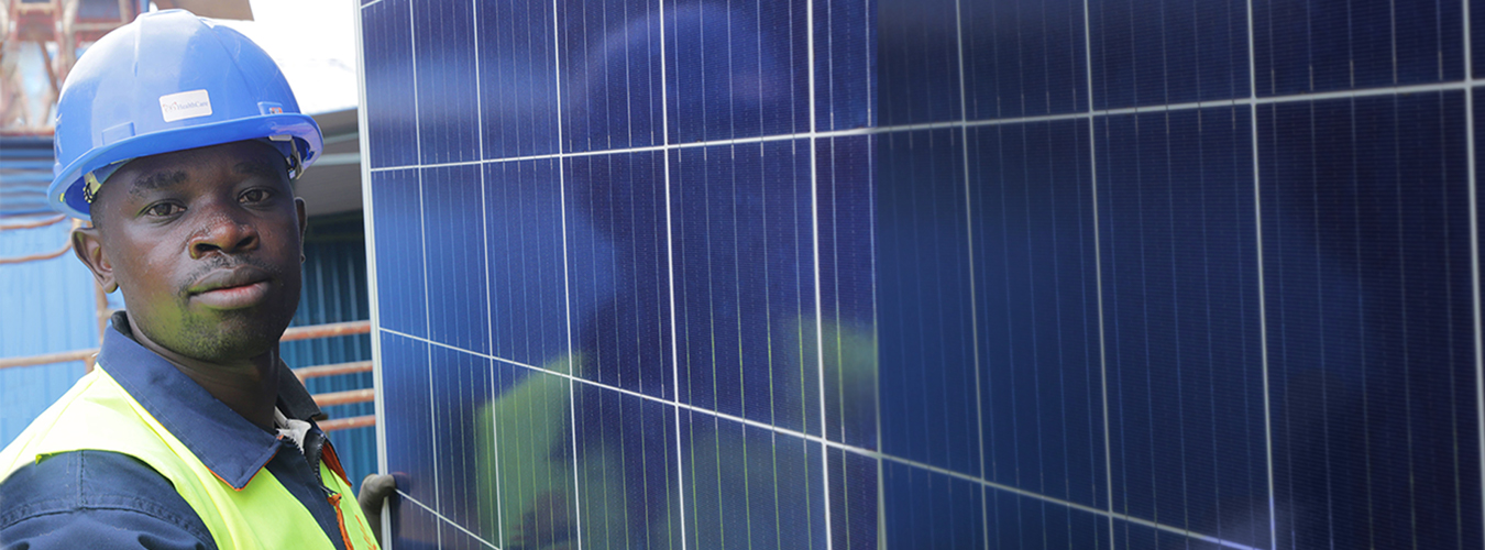 man next to solar panel