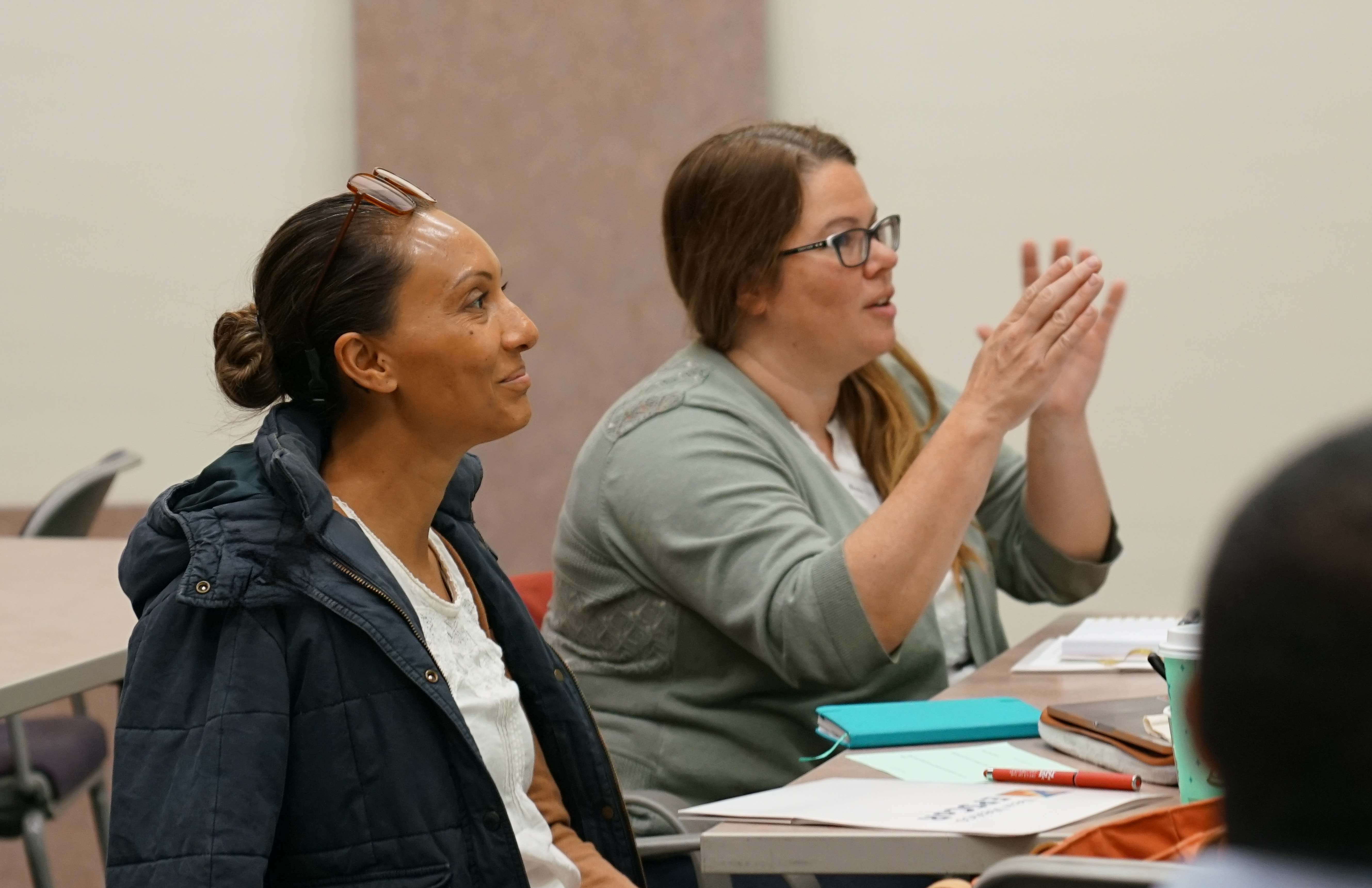 Two women smiling while talking during workshop