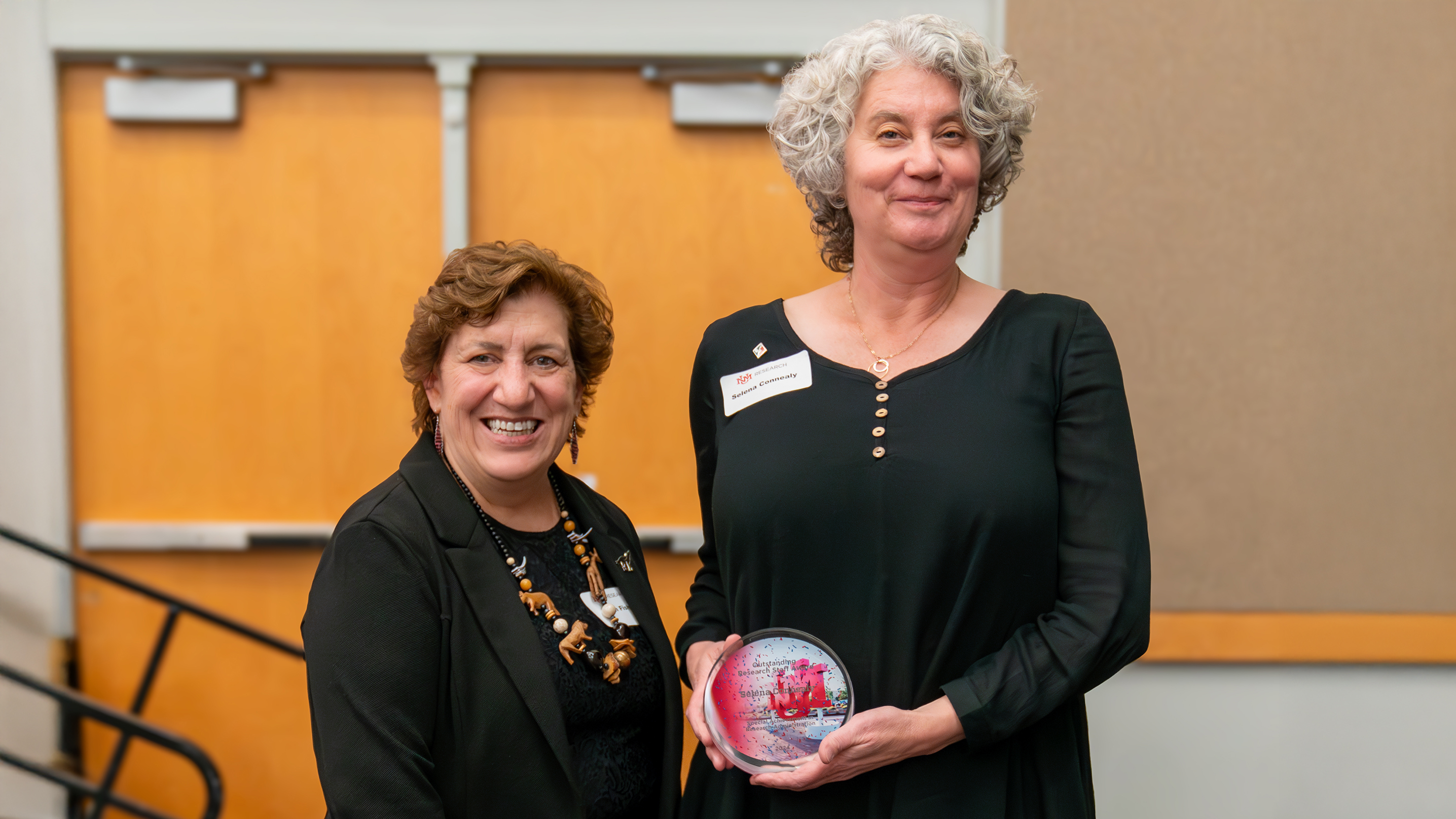 UNM Vice President for Research Ellen Fisher presents Selena Connealy, Associate Director of NM EPSCoR, with an Outstanding Research Staff Award.