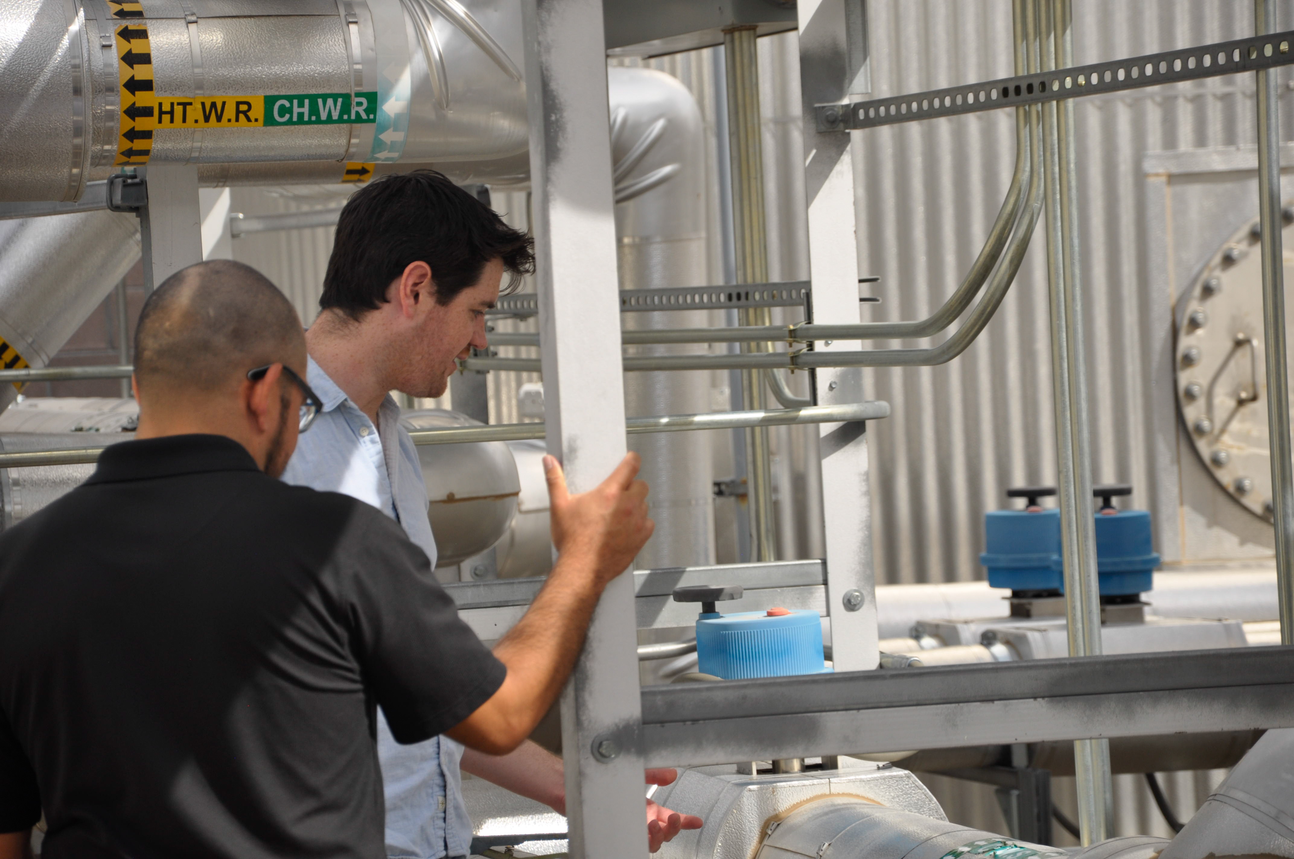 Two students working at mesa del sol microgrid site