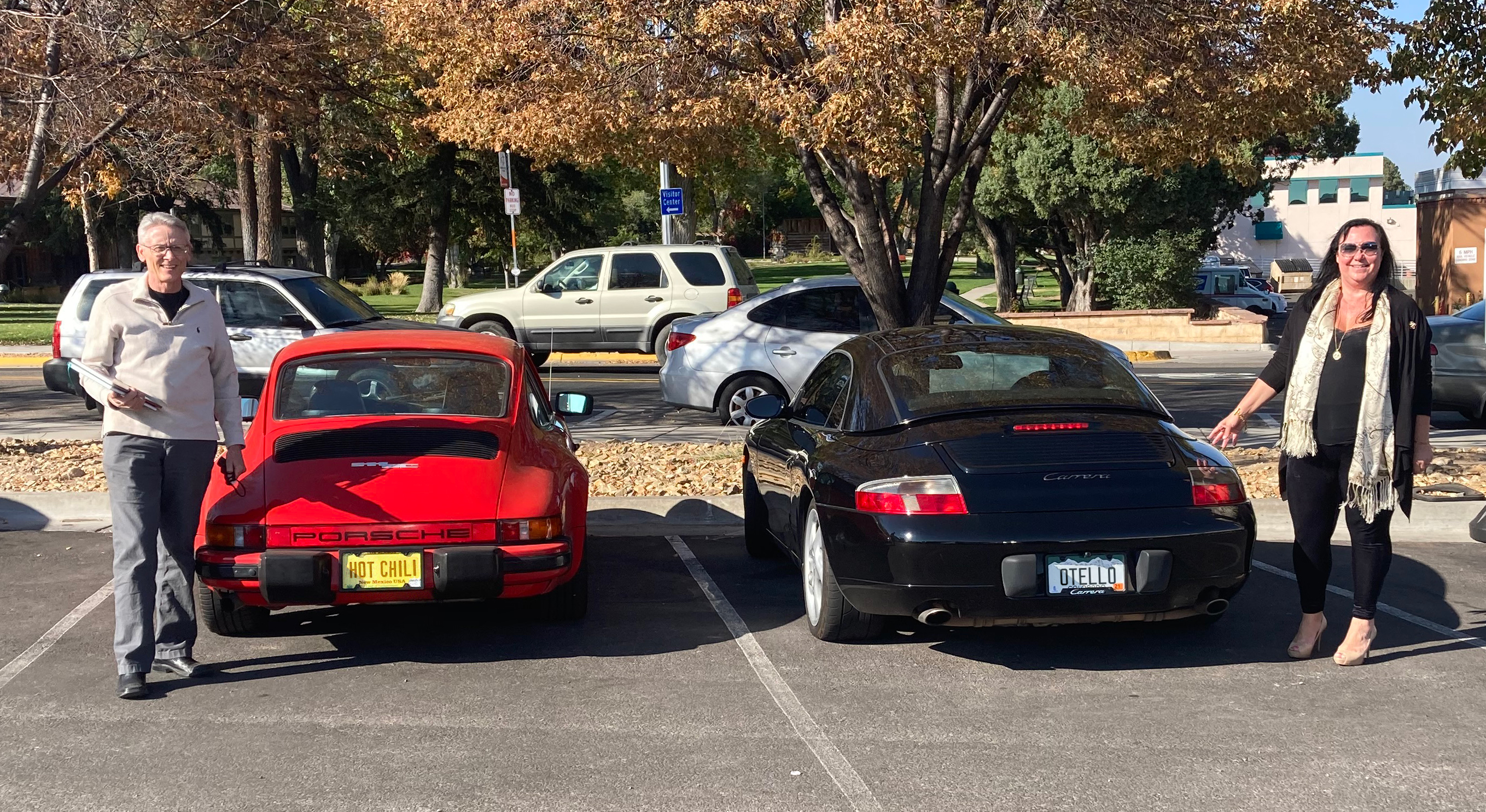 two people standing by cars