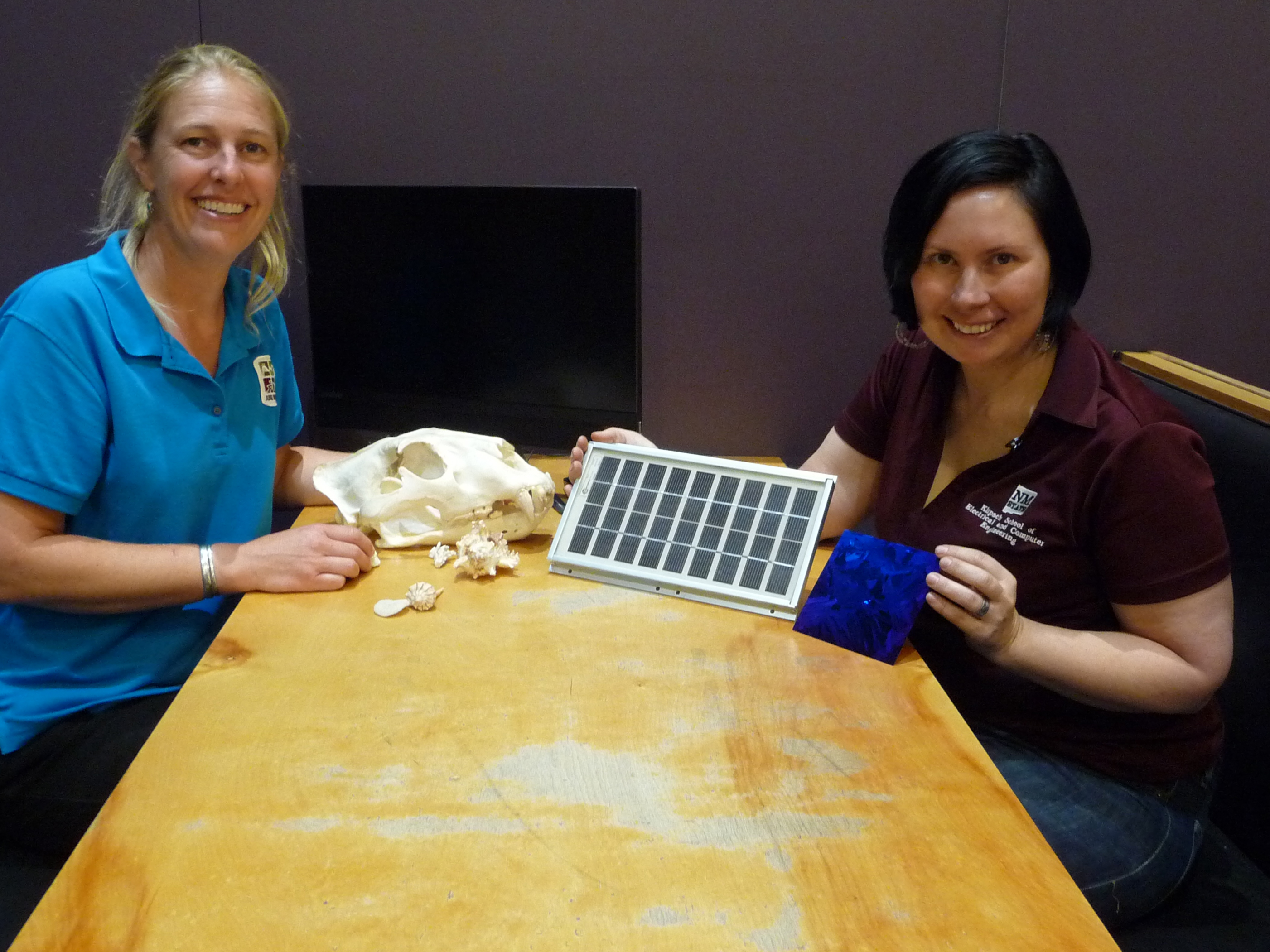 Picture of two women showing booth materials at teen science night