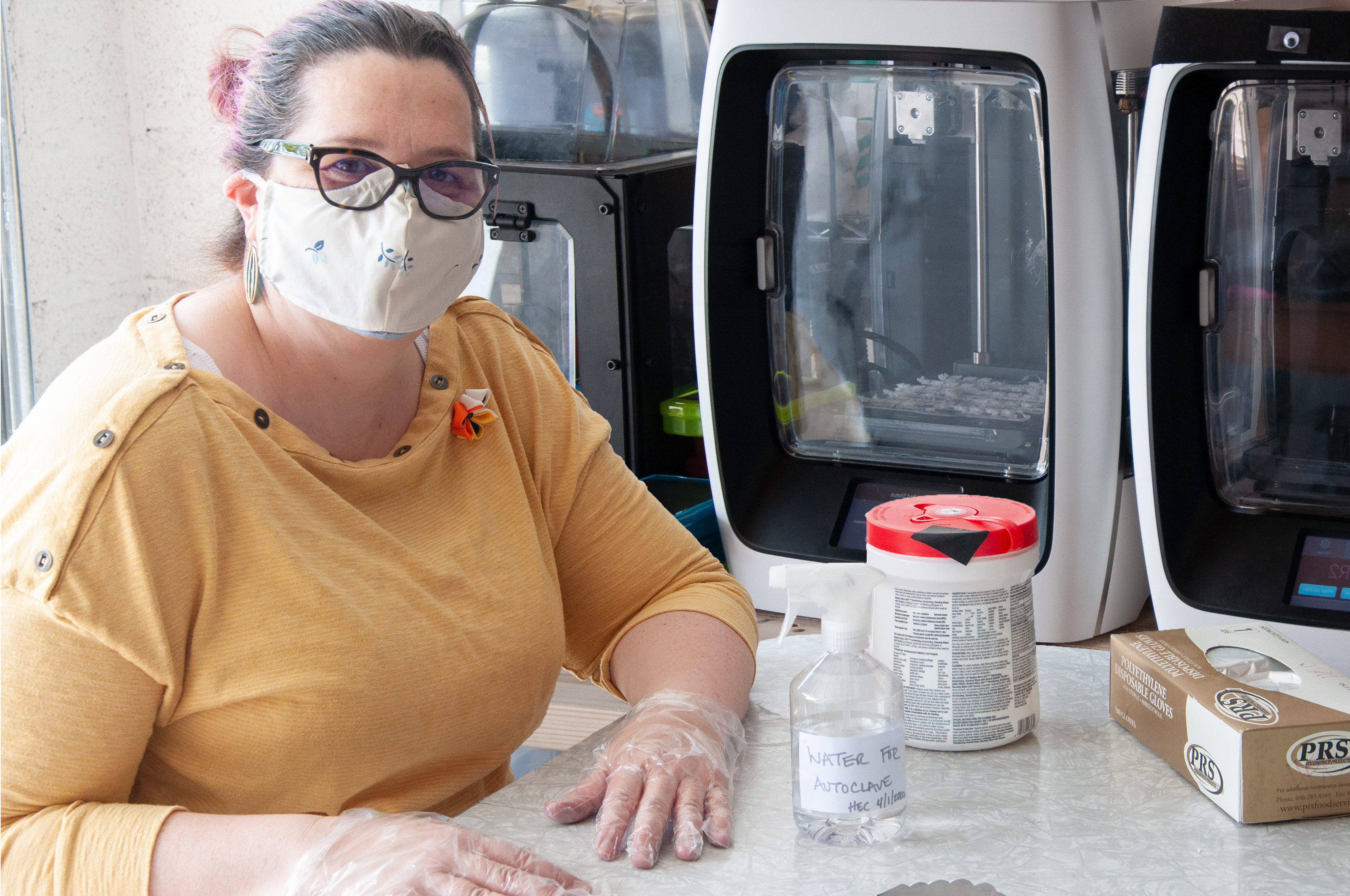 Professor Heather Canavan in her garage lab with 3D printers making protective face masks.