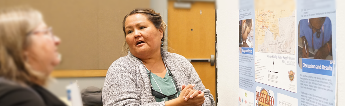 woman at research conference explaining results of poster