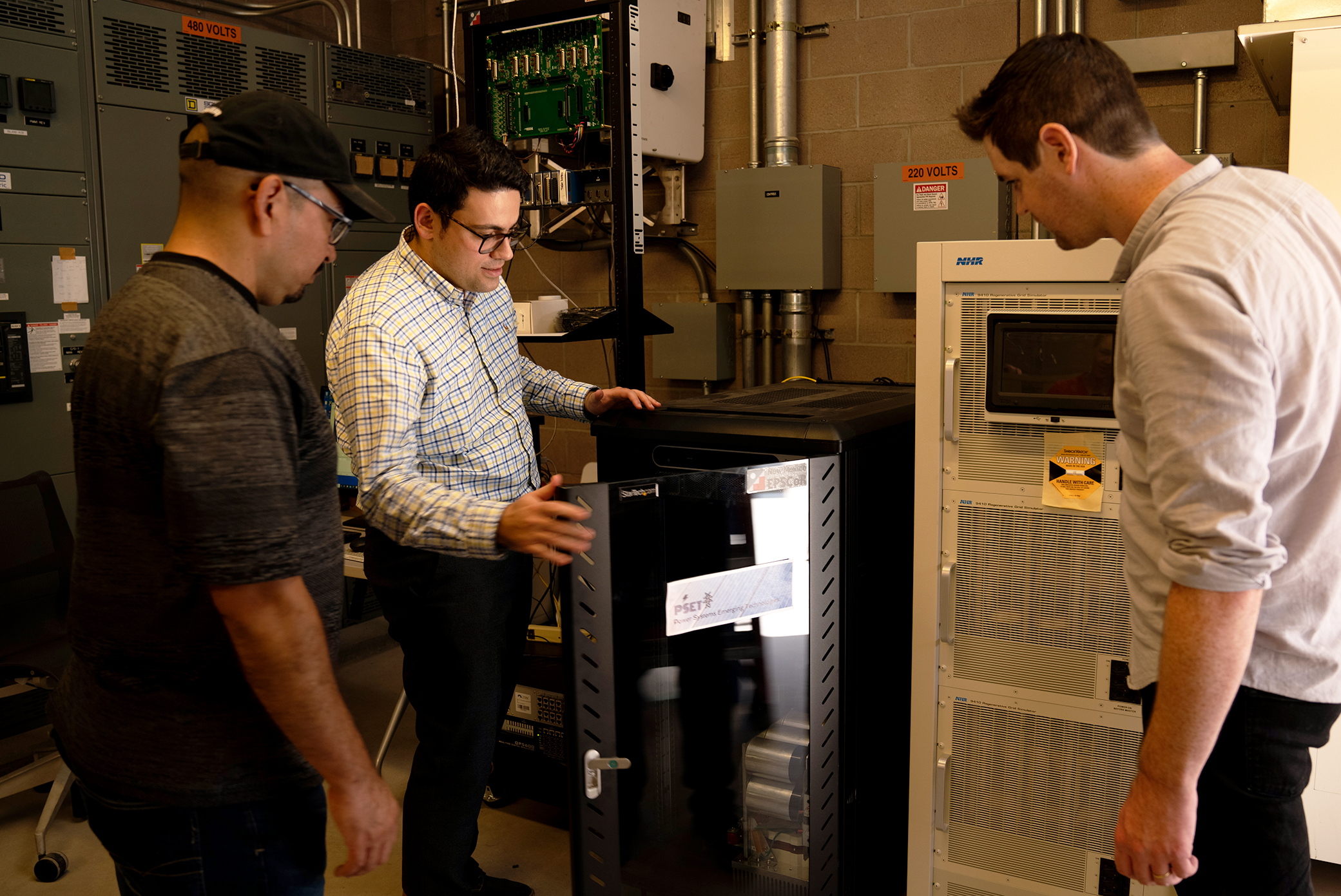 Ali Bidram showing to two students something in his lab